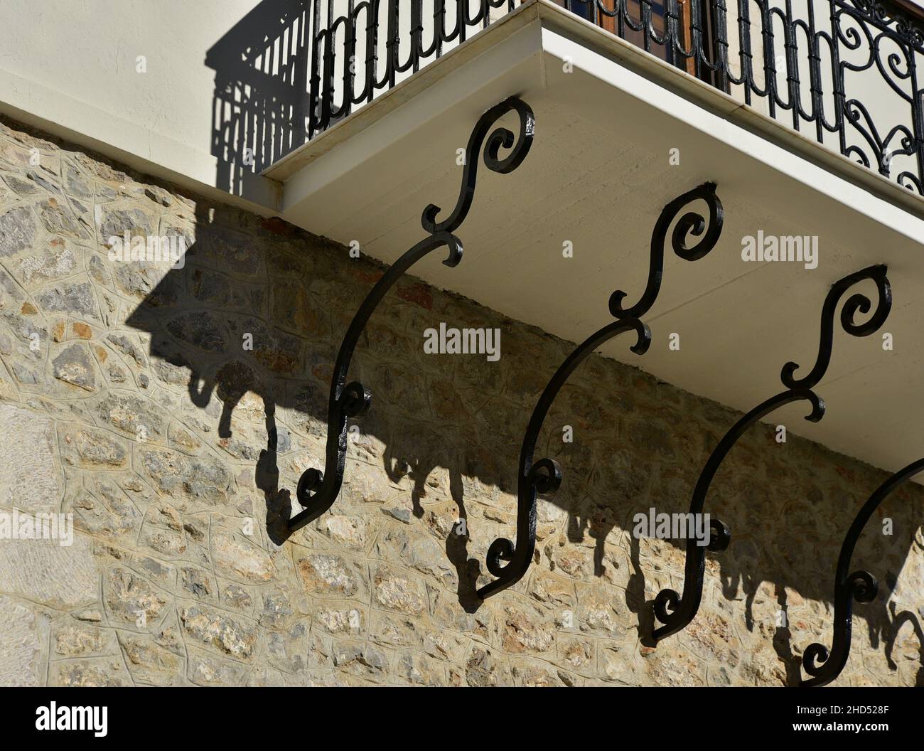 Antica casa rurale tradizionale balcone con una ringhiera artigianale in ferro  battuto e staffe di supporto su un muro di pietra a Leonidio, Arcadia  Grecia Foto stock - Alamy