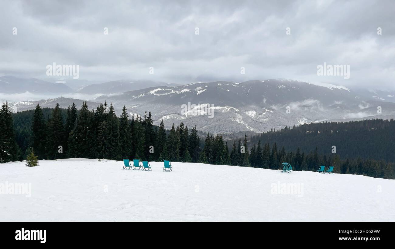 Vista panoramica sulle montagne innevate. Sedie vuote sulle piste da sci. Stazione sciistica per sport invernali, vacanze invernali, sport estremi. Foto Stock