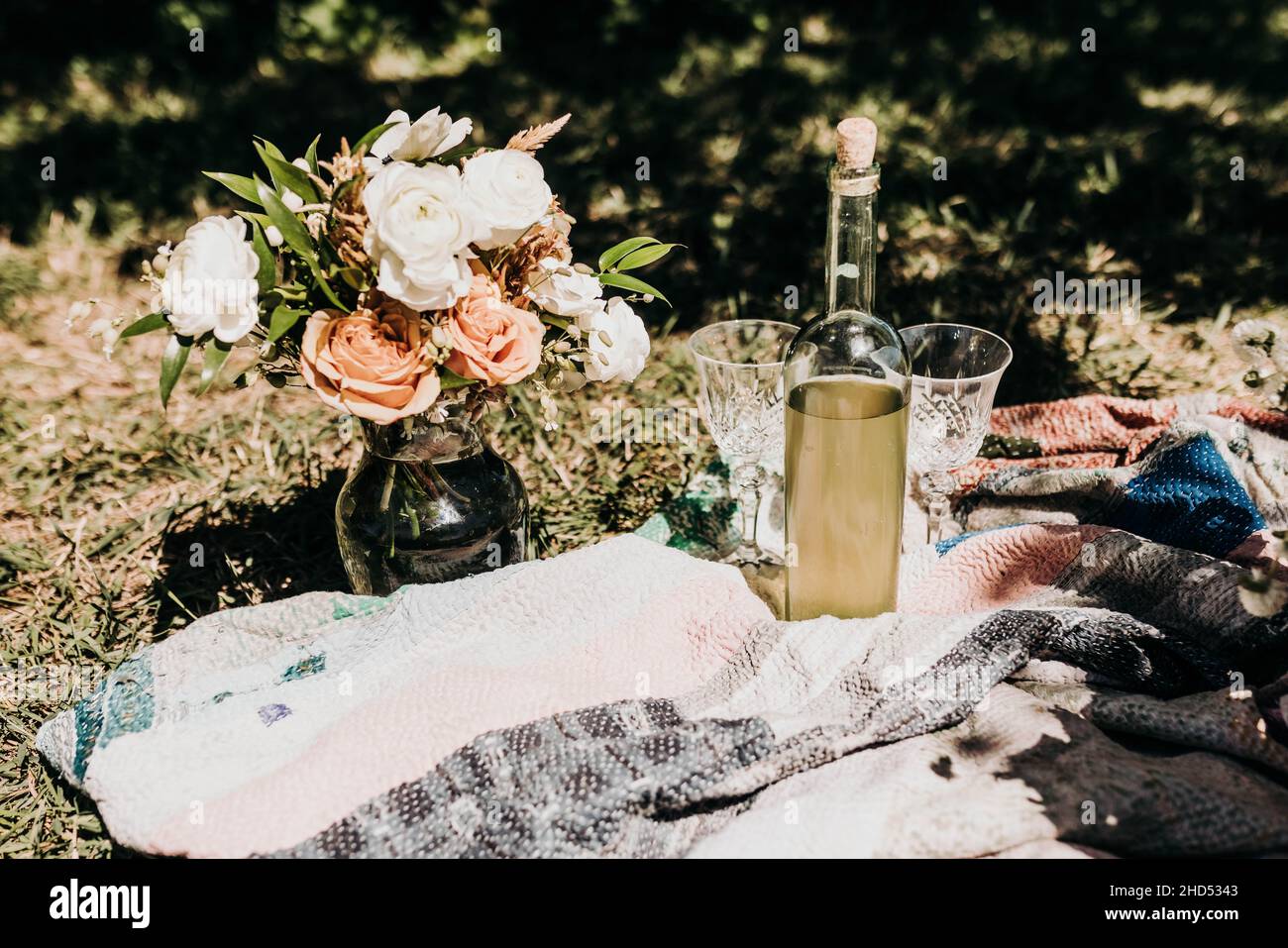 Fiori freschi recisi in vaso al pic-nic con bicchieri e vino Foto Stock