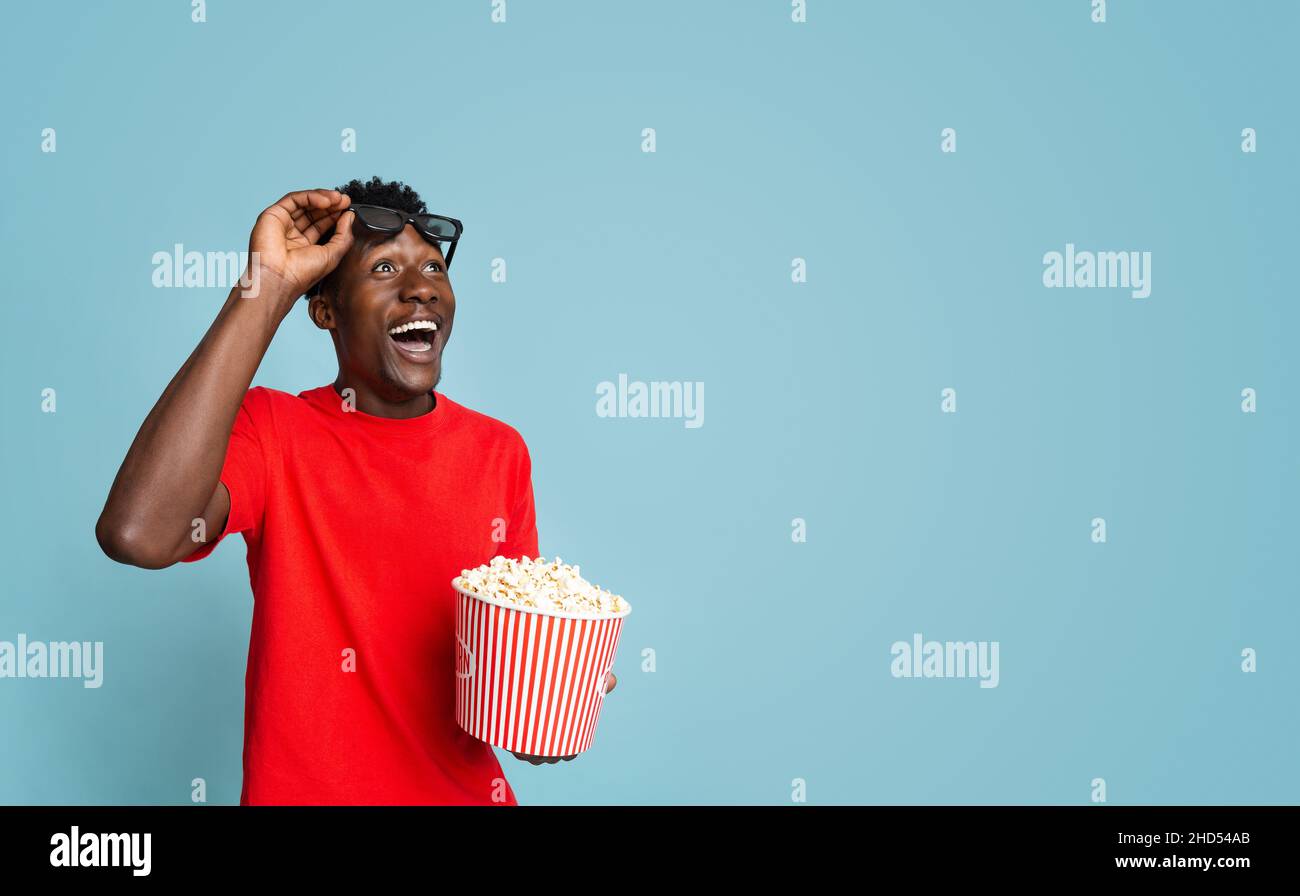 Offerta cinema. Black Guy con Popcorn guardando Copy Space con stupore Foto Stock