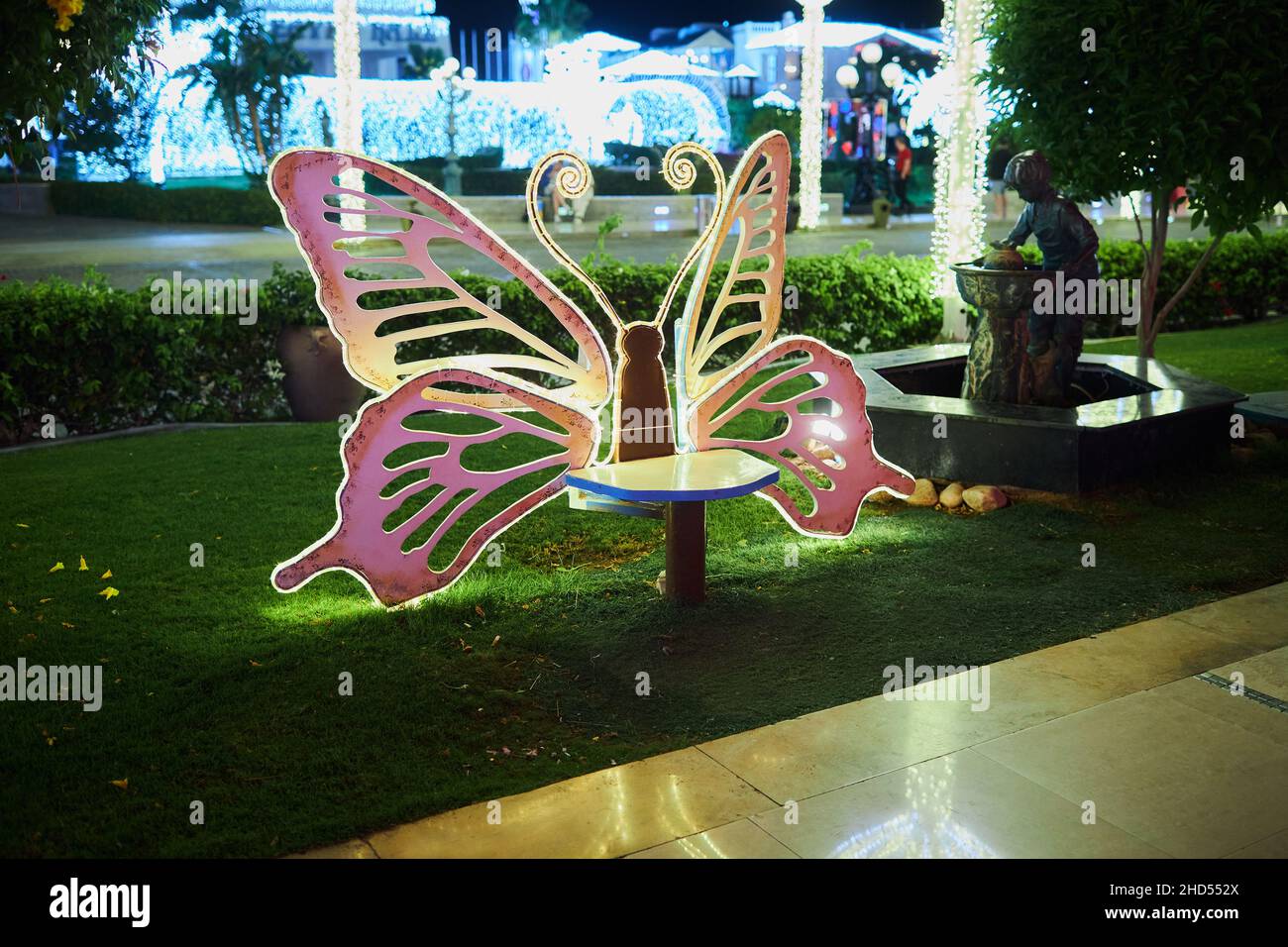 Sharm El Sheikh, Egitto - 20 novembre 2021: Ali di farfalla incandescenti vicino alla panchina nel quartiere dello shopping e del divertimento di Soho Square Foto Stock