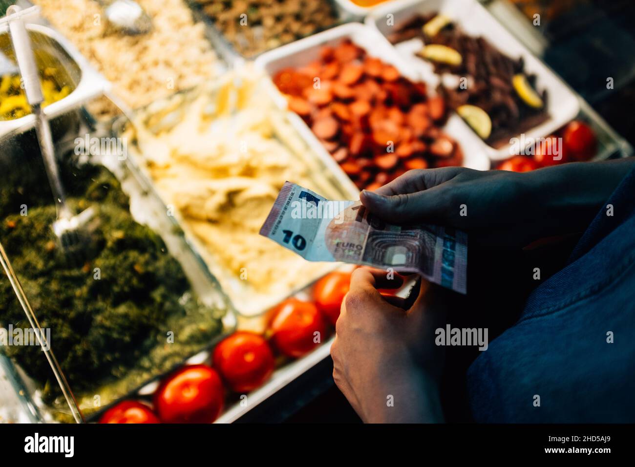 Primo piano sparato sulle mani di un uomo che tiene soldi per comprare cibo nel mercato Foto Stock