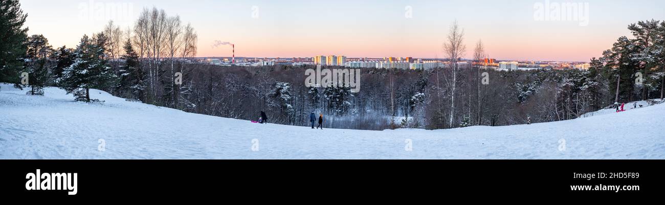 Persone che slittano su una collina innevata a Tallinn, Mustamäe Nõmme. Bellissimo inverno in Estonia con molta neve. Foto Stock