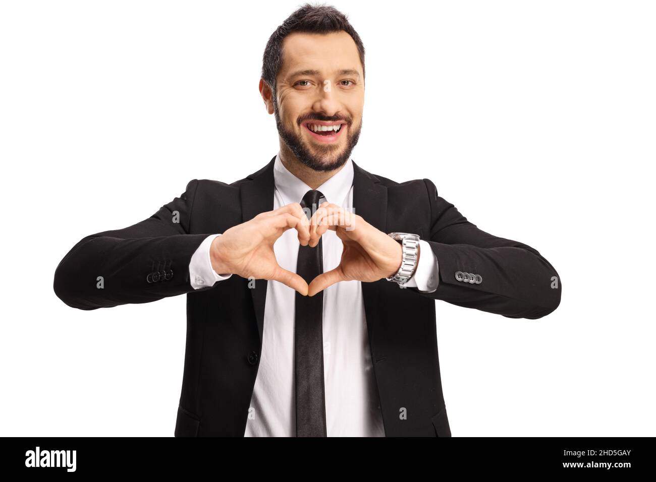 Giovane uomo in abito e cravatta gesturando un simbolo di cuore con le mani isolate su sfondo bianco Foto Stock