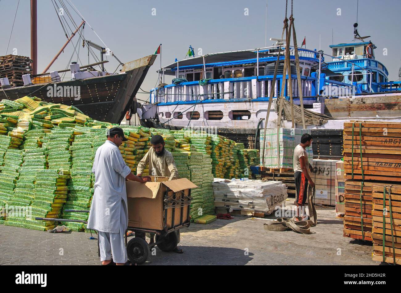 Il carico delle merci sul Trading Dhow sul Dubai Creek, Deira, Dubai, Emirati Arabi Uniti Foto Stock