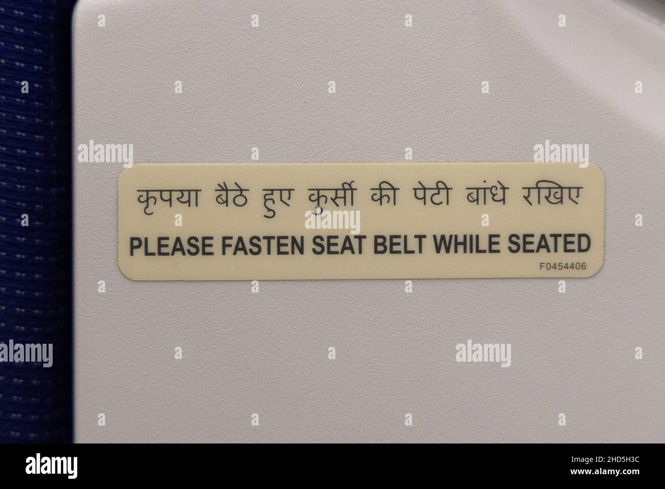 Adesivo delle istruzioni di sicurezza dell'aeroplano che indica di allacciare la cintura di sicurezza mentre è seduto Foto Stock