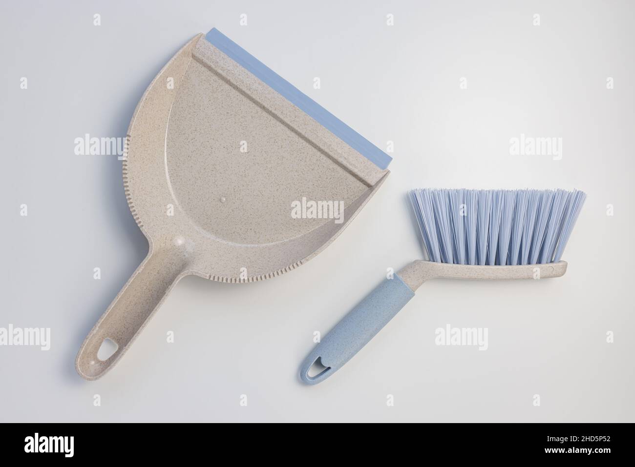Set di sessola per il cestino dei rifiuti. Paletta in plastica grigia e blu e spazzola a mano su sfondo bianco. Pulizia della casa, chores concetto domestico. Vista dall'alto, spazio di copia Foto Stock