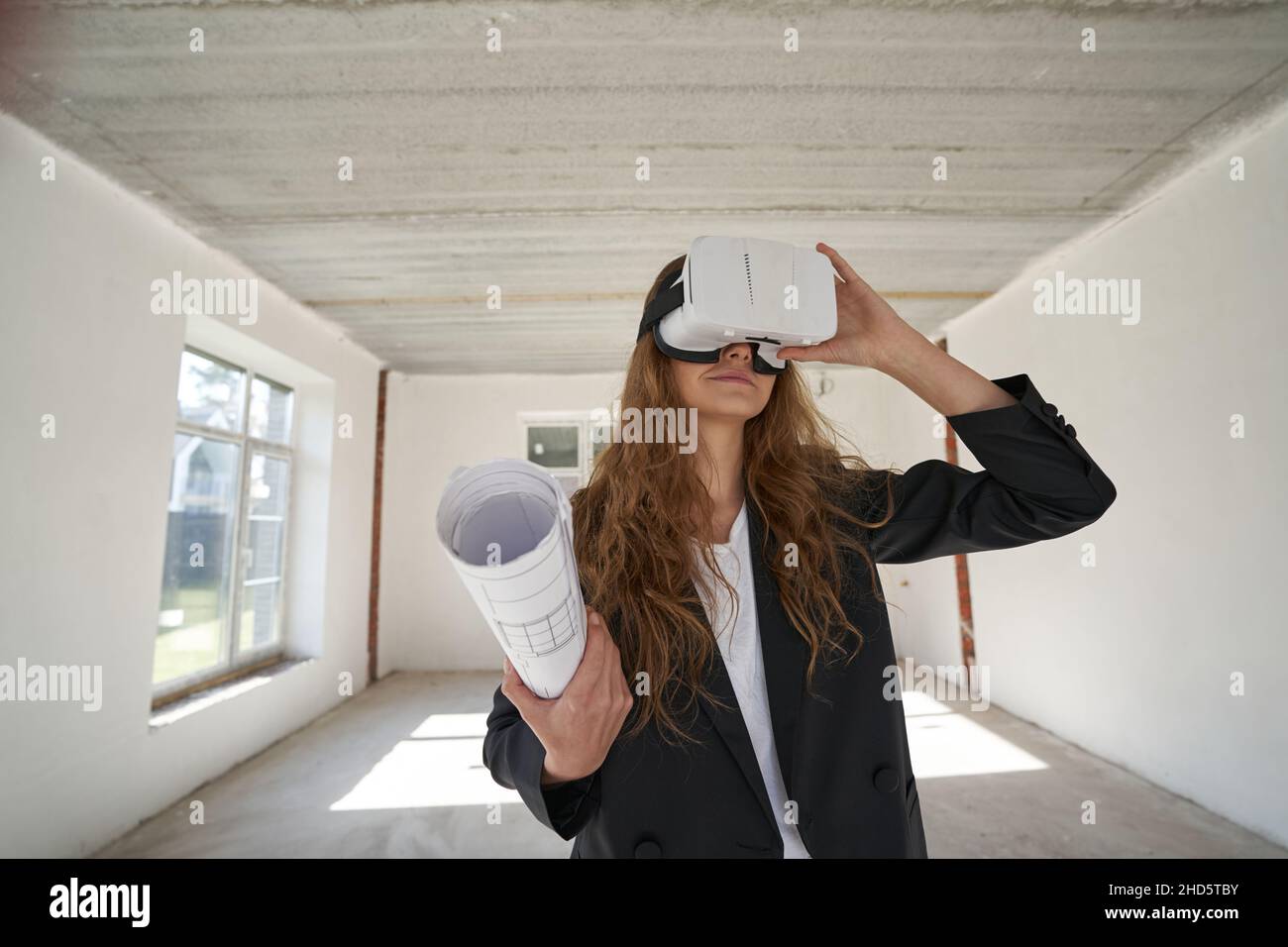 Donna disegnatrice con disegni utilizzando occhiali di protezione per la realtà virtuale in ambienti chiusi Foto Stock