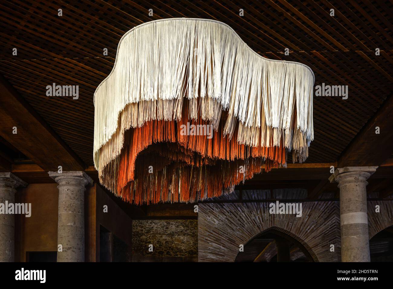 Un lampadario in fibra più unico e creativo in tre colori e tre lunghezze di materiale simile a corda in forma di ameba è appeso in ristorante, SMA, Messico Foto Stock