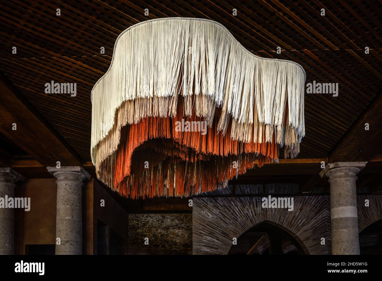 Un lampadario in fibra più unico e creativo in tre colori e tre lunghezze di materiale simile a corda in forma di ameba è appeso in ristorante, SMA, Messico Foto Stock