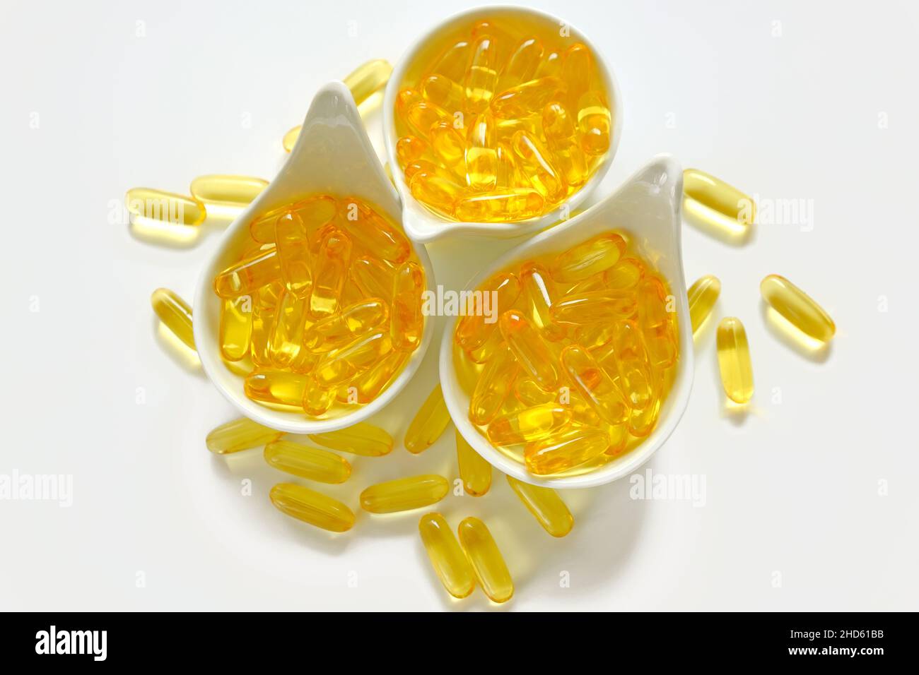 Fish OIL.omega 3 capsule di gelatina in tazze di ceramica bianca su sfondo bianco.omega grassi acidi.integratori naturali Foto Stock