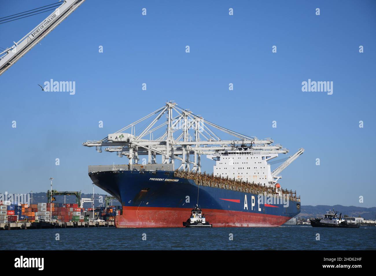 Tugs docking nave container APL Presidente Eisenhower, Porto di Oakland. Trasporto commerciale e navi container a San Francisco Bay, California Foto Stock