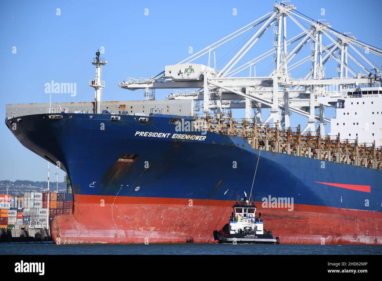 Tugs docking nave container APL Presidente Eisenhower, Porto di Oakland. Trasporto commerciale e navi container a San Francisco Bay, California Foto Stock