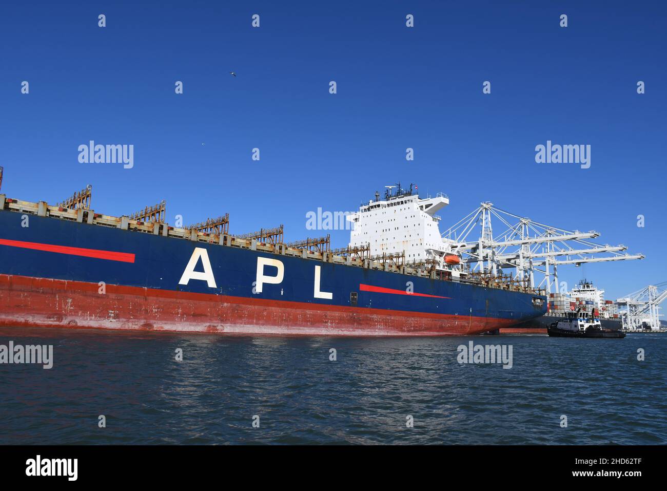 Tugs docking nave container APL Presidente Eisenhower, Porto di Oakland. Trasporto commerciale e navi container a San Francisco Bay, California Foto Stock