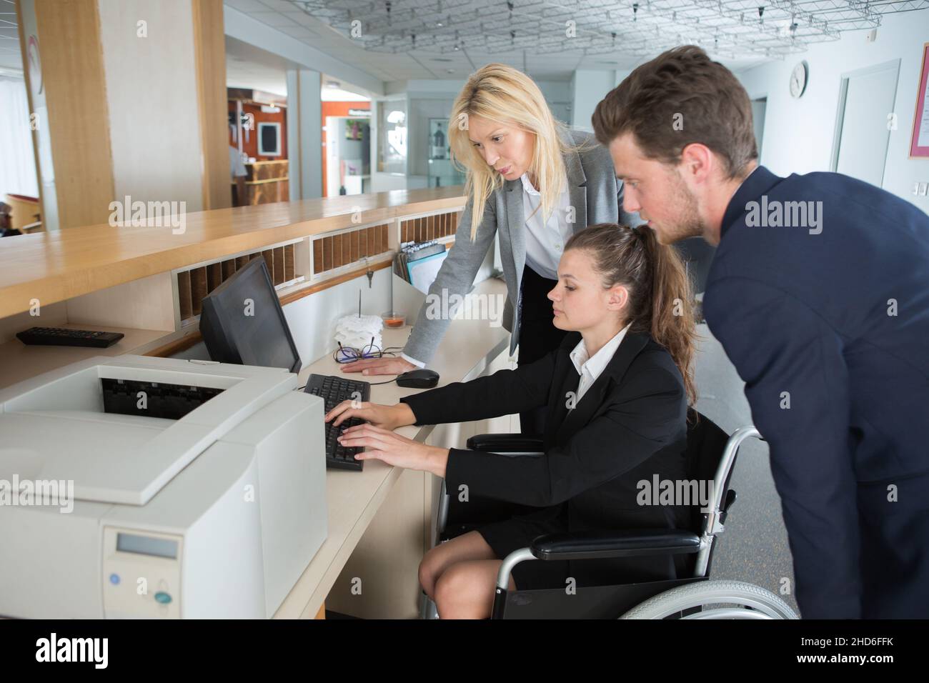 lavoratore in sedia a rotelle che lavora al computer Foto Stock