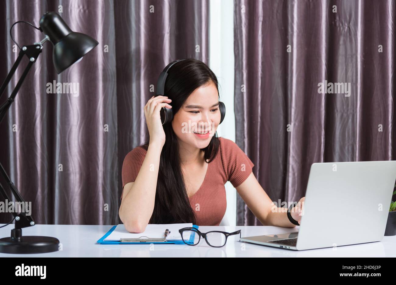 Lavoro da casa, giovane donna d'affari asiatica sorridente con cuffie,  videochiamata in conferenza o facetime con computer portatile incontro con  il team alla scrivania a h Foto stock - Alamy