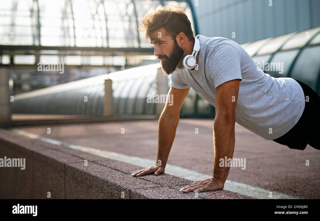 Felice giovane uomo in forma che si esercita e gode di uno stile di vita sano. Concetto di corsa per le persone sportive Foto Stock