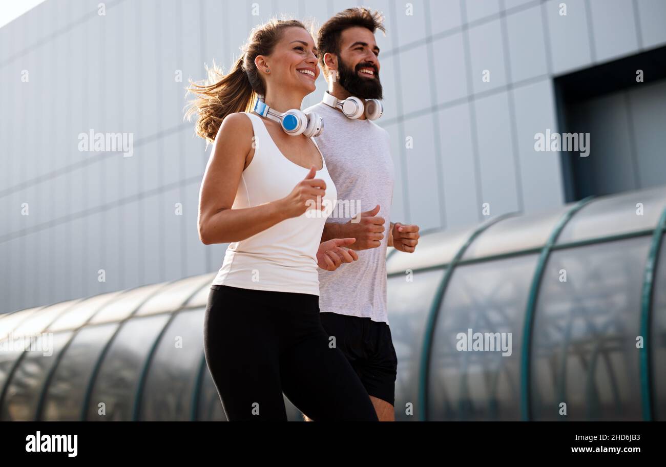 Coppia felice runner che si esercita all'esterno come parte di stile di vita sano. People sport corsa concetto Foto Stock