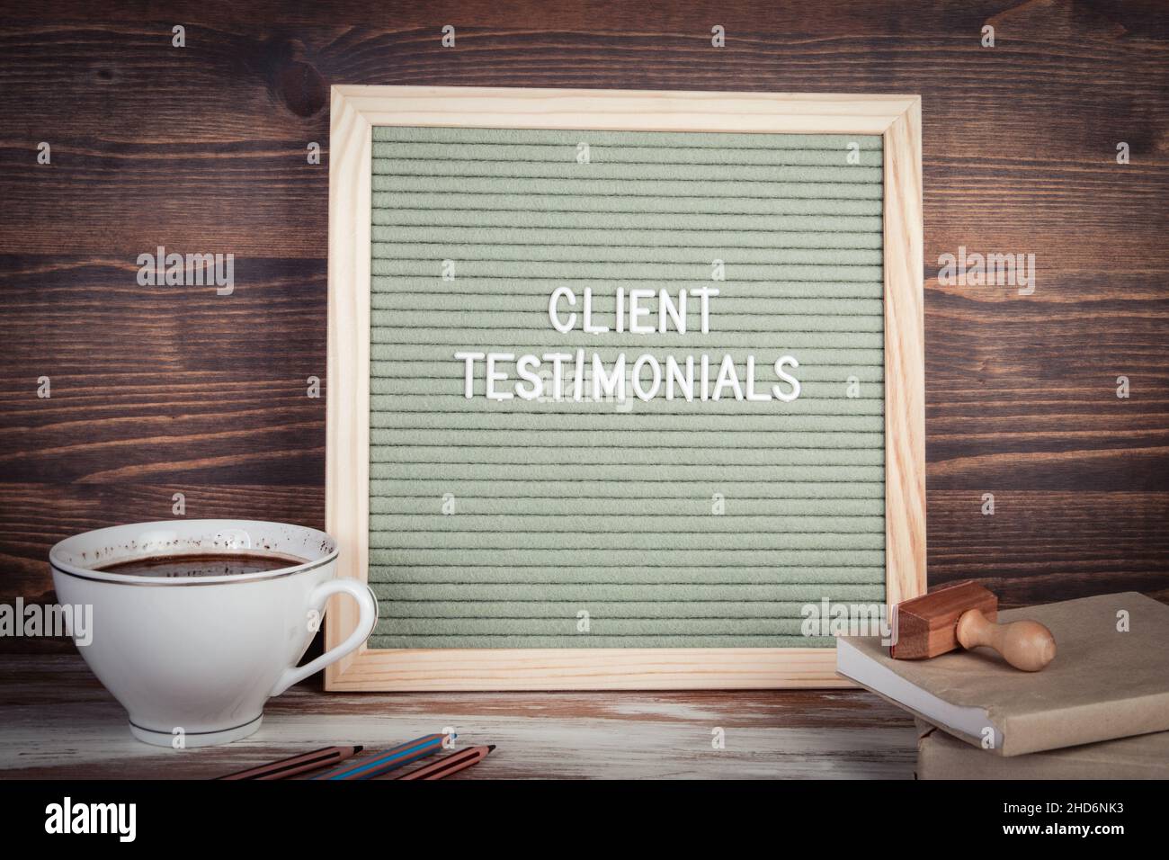 Testimonianze dei clienti. Testo in inglese su una lettera Board. Cancelleria su un tavolo di legno. Foto Stock