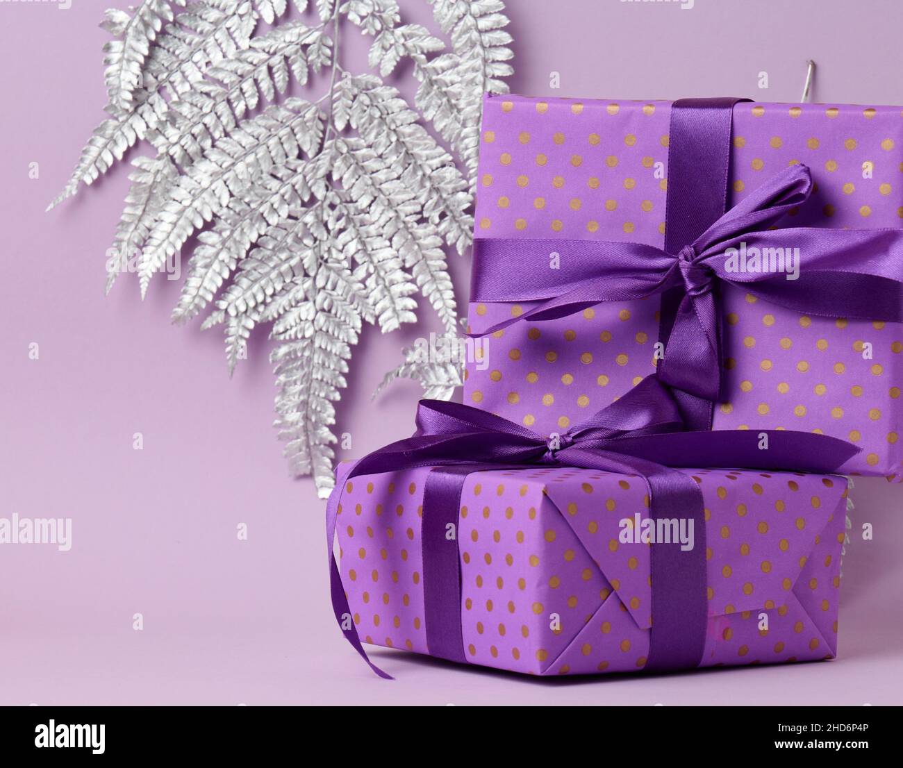 scatole confezionate in carta viola festiva e legate con nastro di seta su  sfondo viola, regalo, sorpresa Foto stock - Alamy