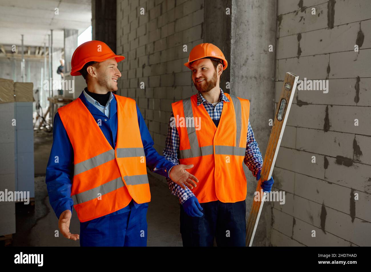 Due costruttori in uniforme a piedi e parlando di costruzione Foto Stock