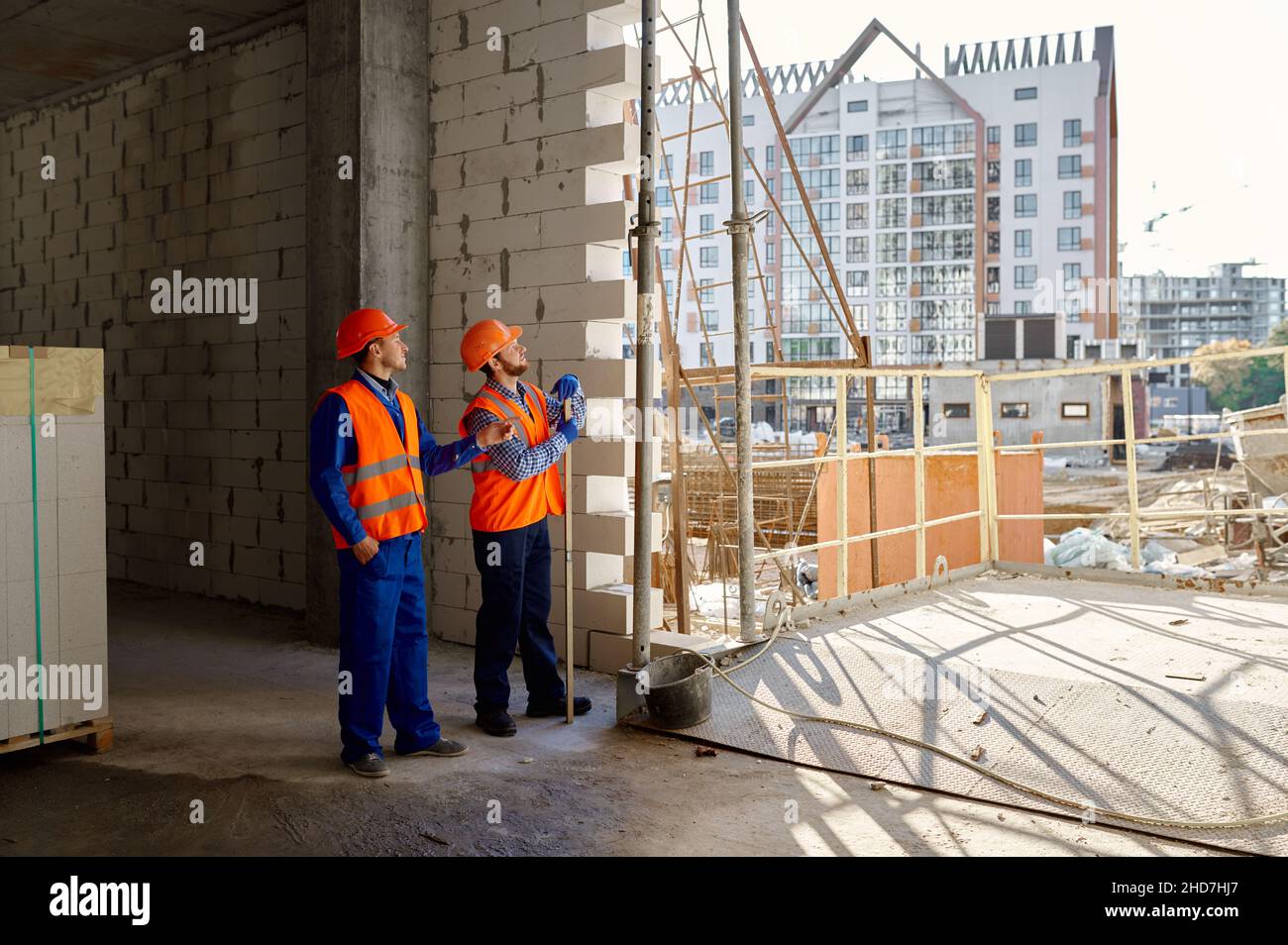 Due costruttori in piedi e parlando di costruzione Foto Stock