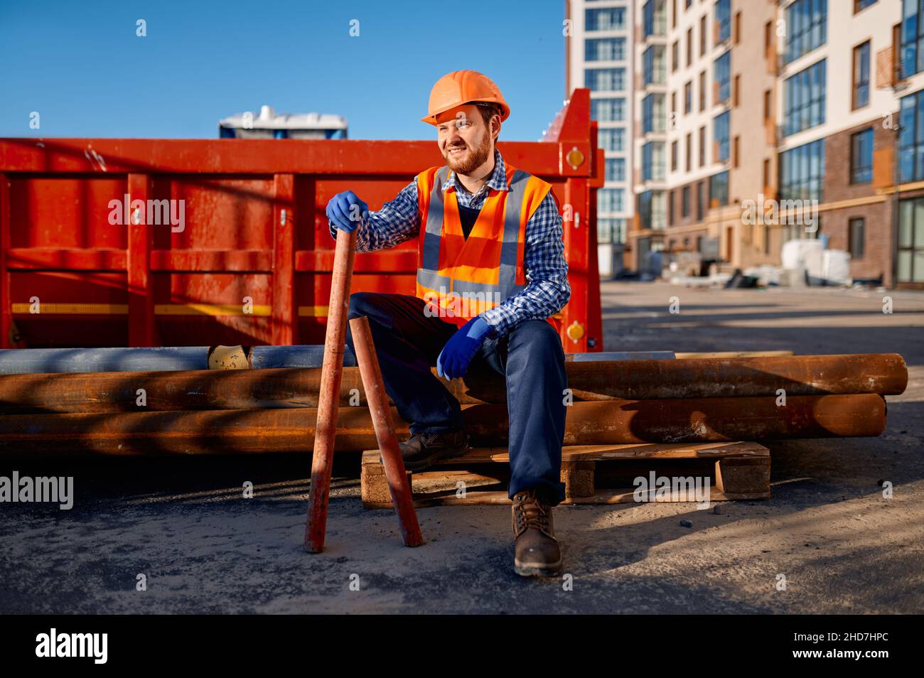 Lavoro di costruzione resto seduto su palo di tubo Foto Stock