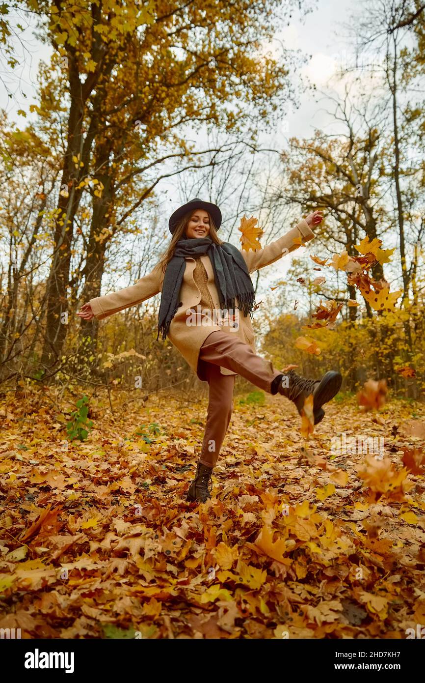 Felice eccitata giovane donna sotto foglie caduta Foto Stock
