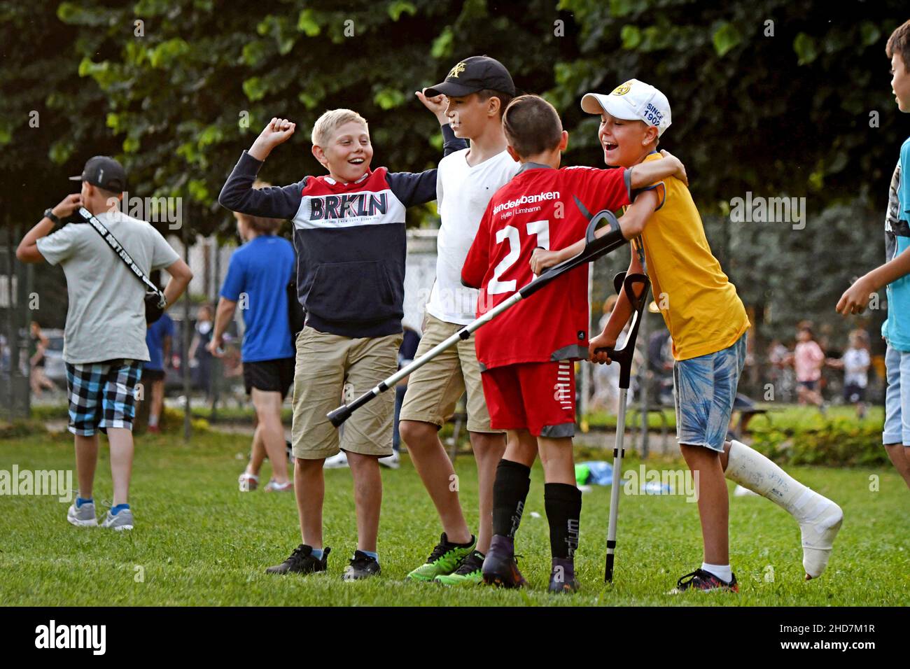 Il giocatore di calcio dei bambini festeggia con il compagno di squadra con la gamba in gesso dopo una ferita di calcio Foto Stock