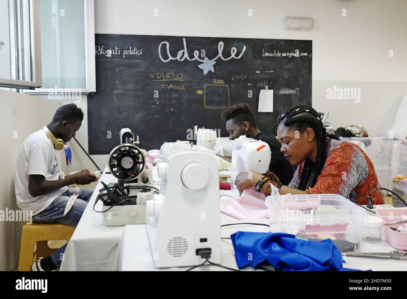 Rifugiati politici che lavorano su una sartoria dell'associazione no-profit linea Adele, a Milano. Foto Stock