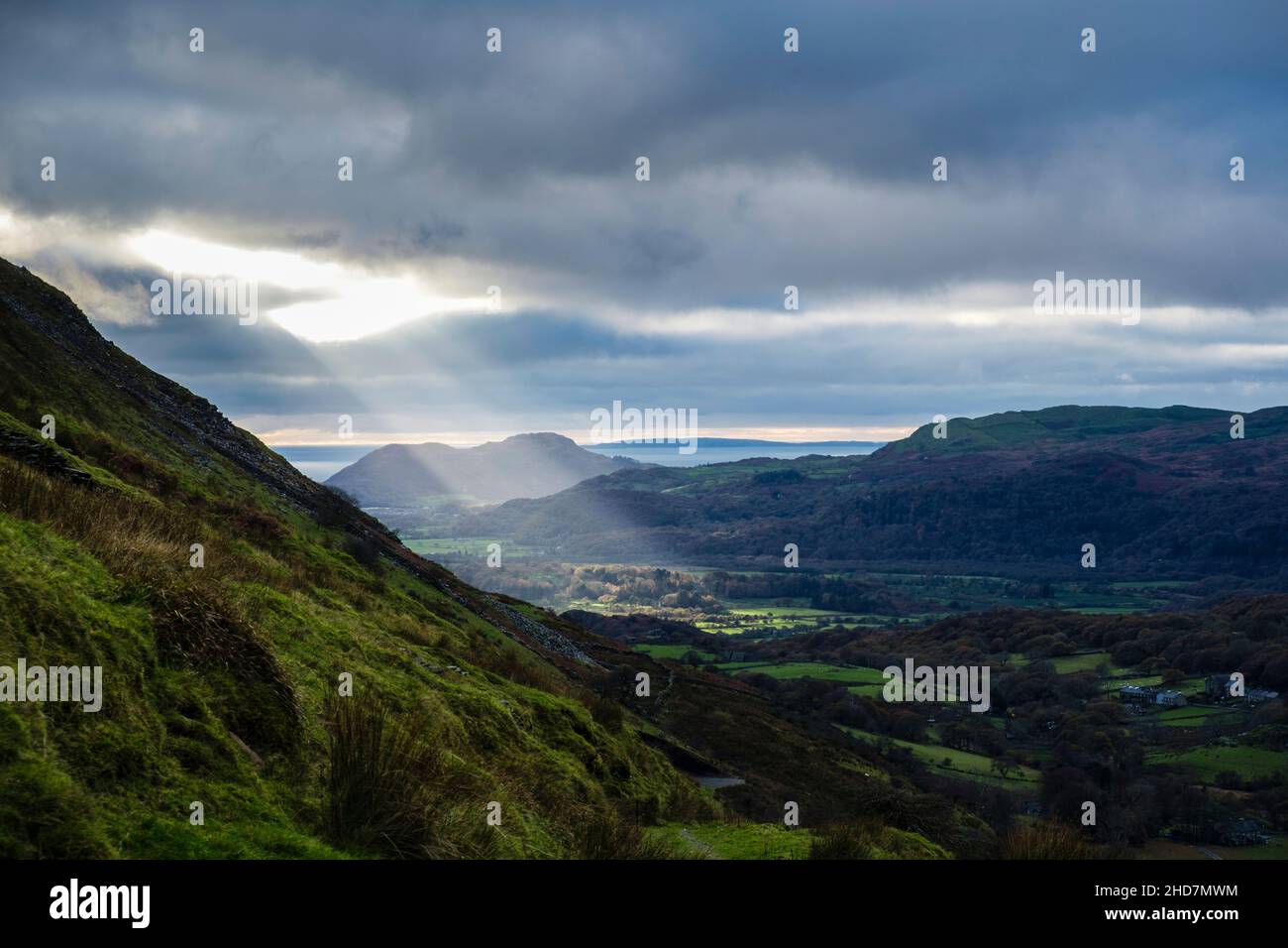 Un albero di luce del sole brilla attraverso un gap nelle nuvole nella valle vista dalla montagna Cnicht. Croesor, Gwynedd, Galles, Regno Unito, Gran Bretagna Foto Stock