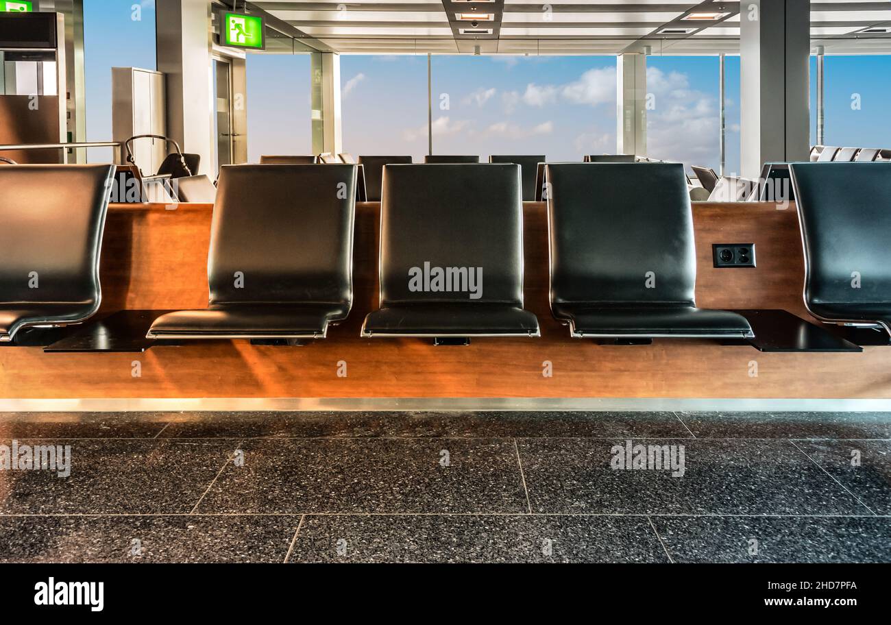Fila di posti vuoti in attesa nella sala partenze dell'aeroporto. Concetto di viaggio e business. Foto Stock