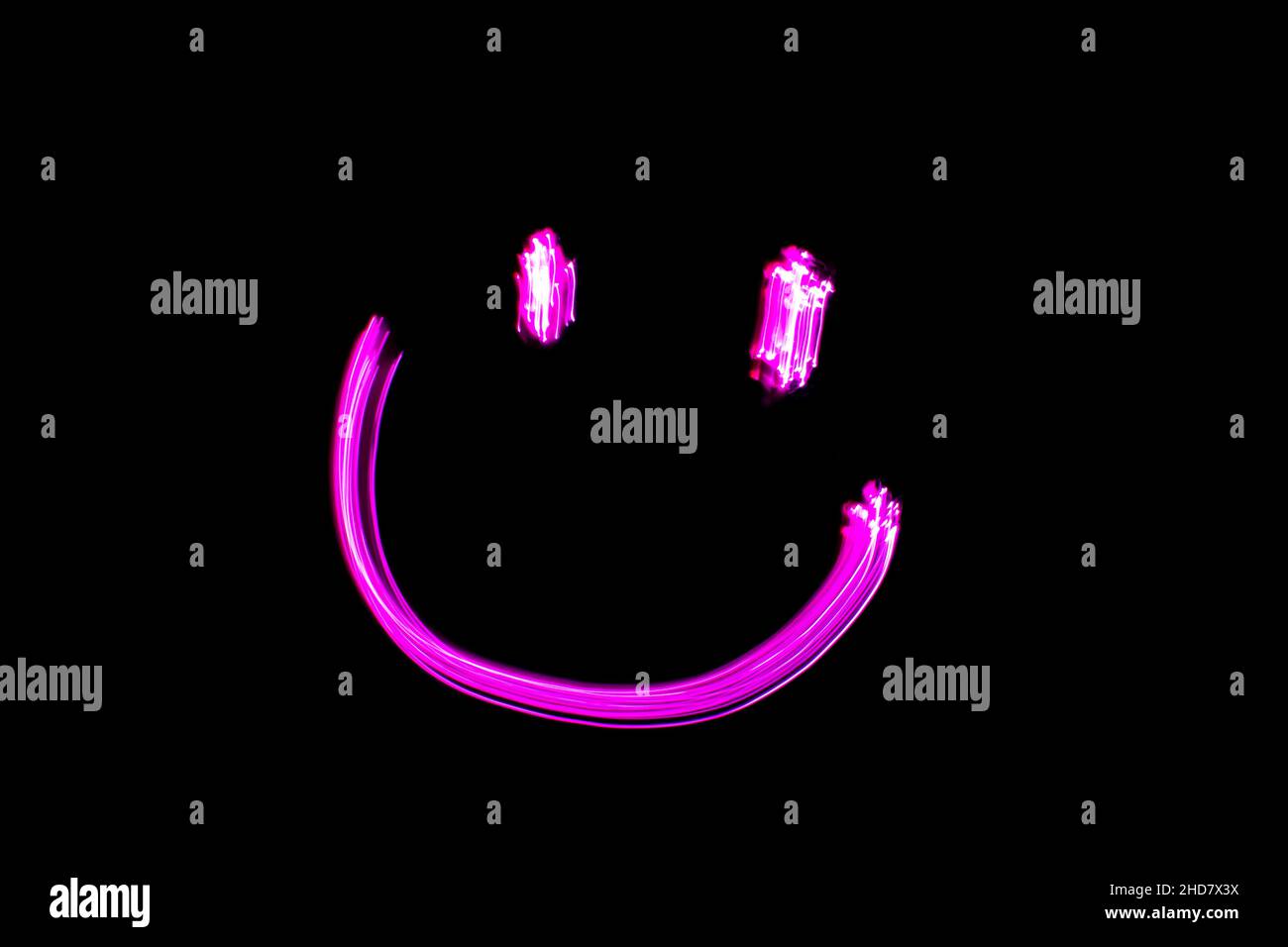 Viso sorridente al neon, viso sorridente rosa dipinto chiaro su sfondo nero. Espressioni facciali emoji. Foto Stock