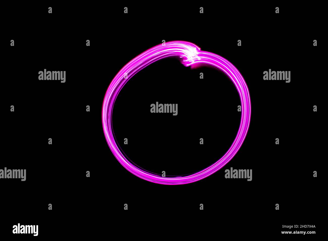 Cerchio rosa con pittura chiara su sfondo nero. Cerchio lucido al neon. Foto Stock