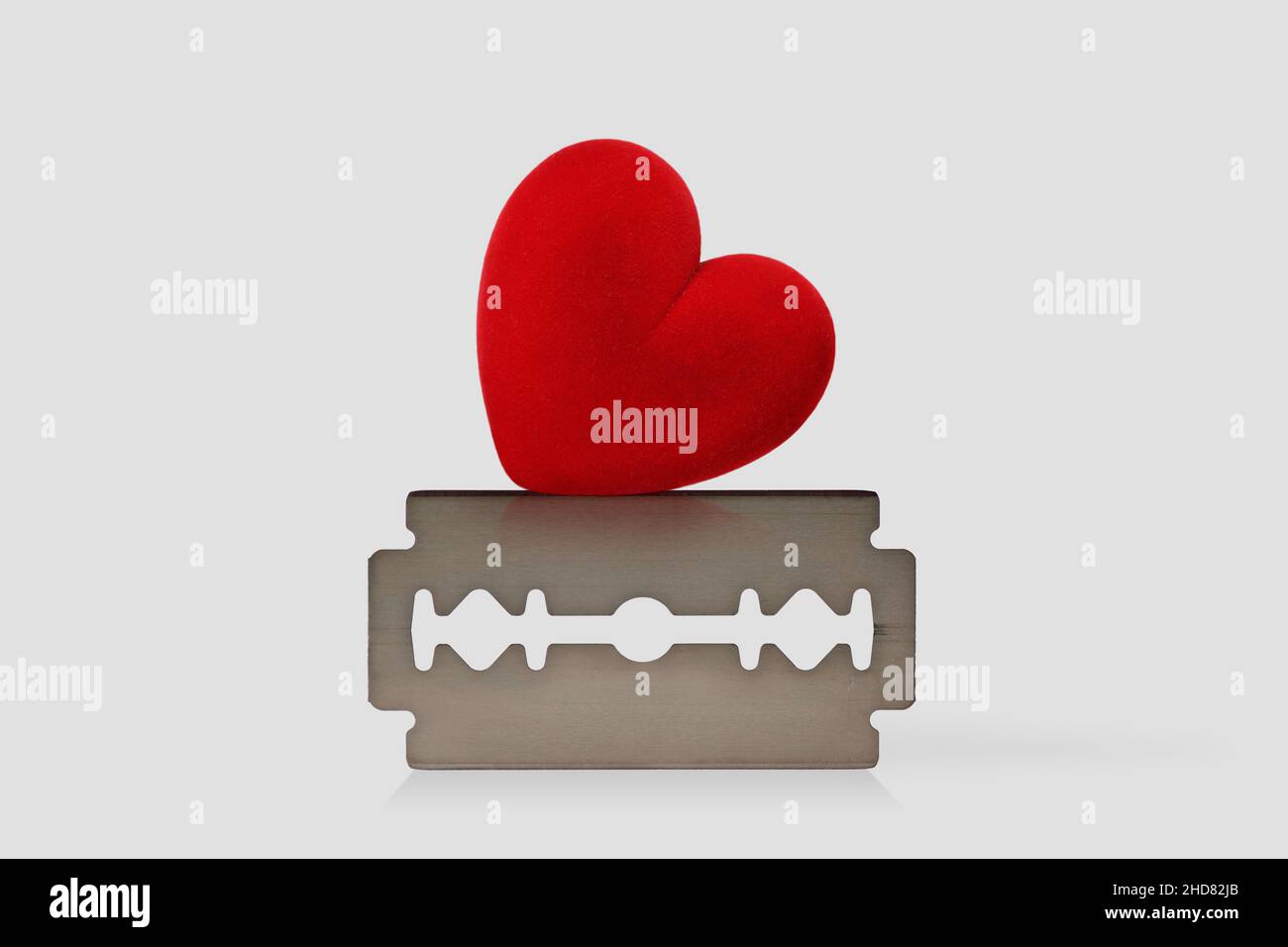 Cuore sulla lama del rasoio - concetto di amore e rischio Foto Stock