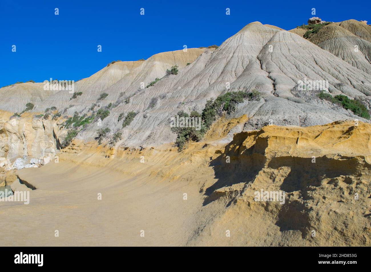 Ripidi pendii di argilla blu, con detriti che scagliano che formano un calcare lungo la costa di Gozo, Malta Foto Stock