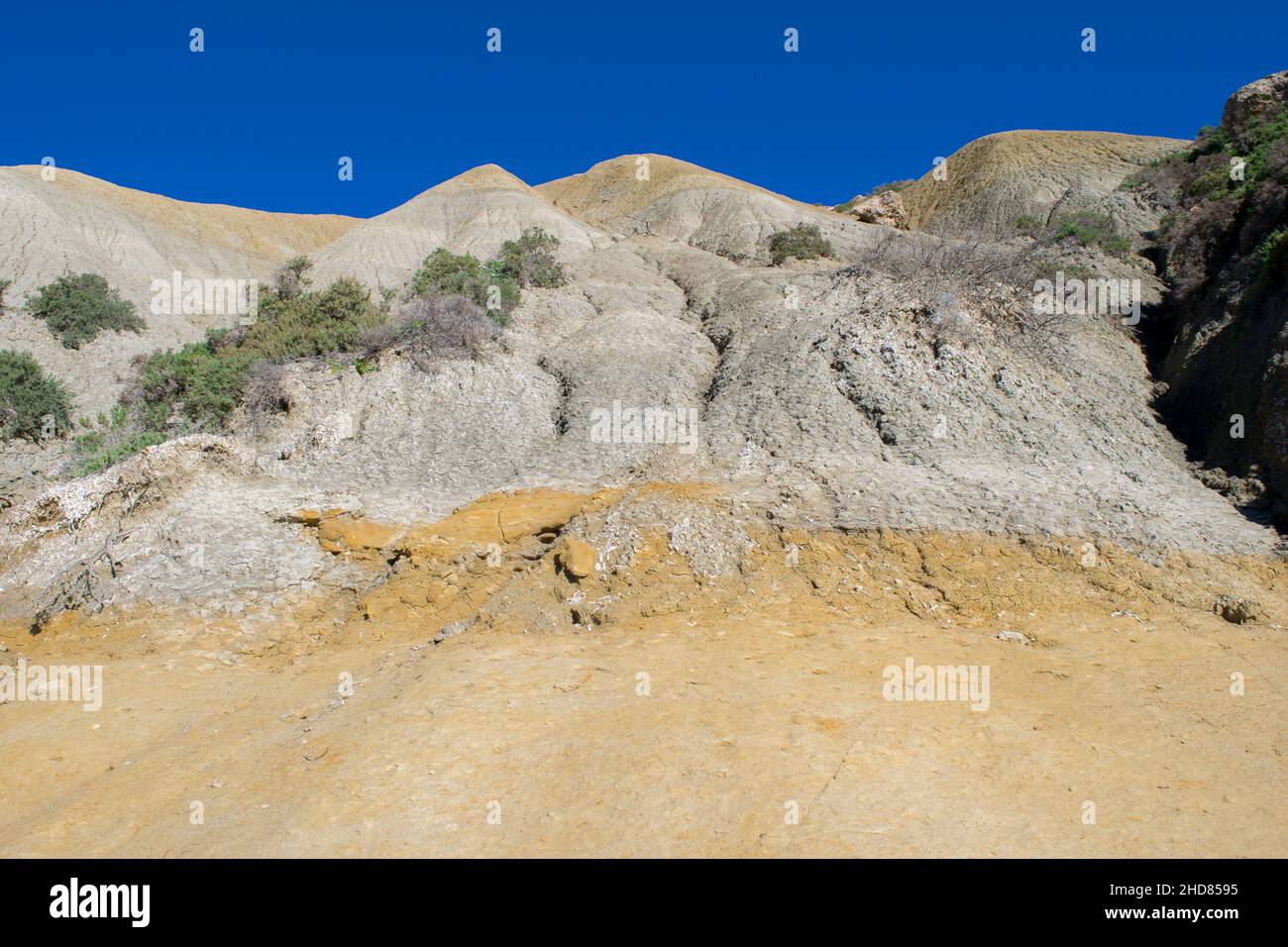 Ripidi pendii di argilla blu, con detriti che scagliano che formano un calcare lungo la costa di Gozo, Malta Foto Stock