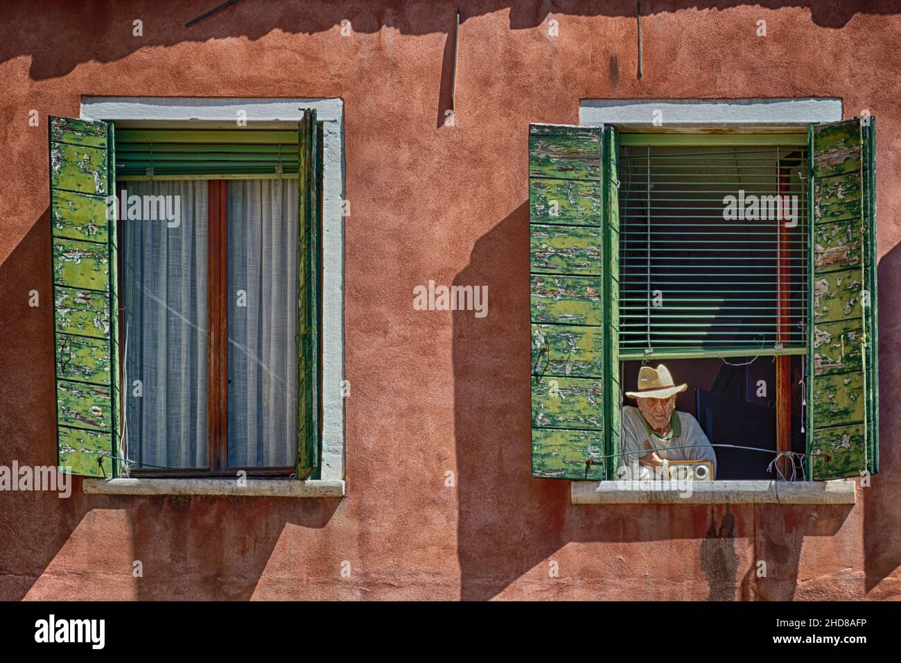 Uomo che guarda il mondo passare dalla sua finestra a Firenze Italia Europa Foto Stock