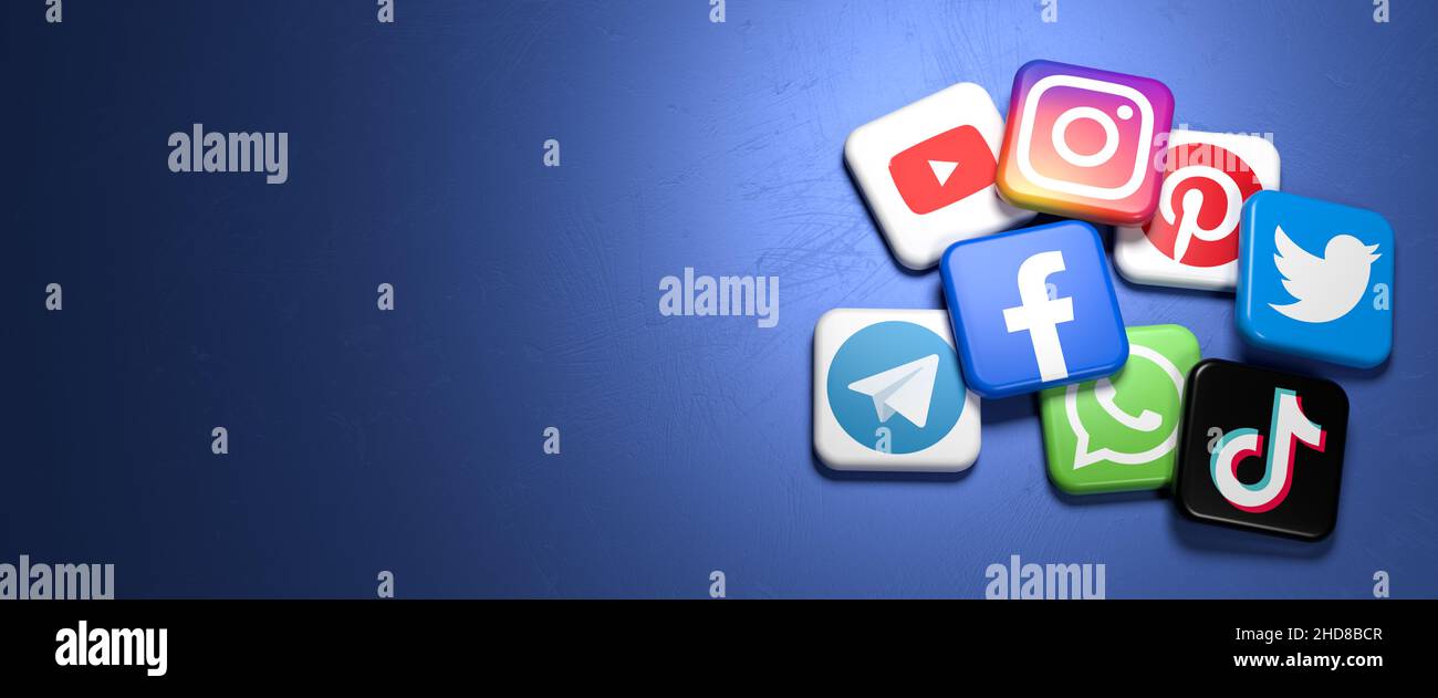 Logo dei principali siti di social media e messaggistica (YouTube, Instagram, Pinterest, Twitter, Facebook, WhatsApp, Telegram, Tiktok) su un mucchio su un blu Foto Stock