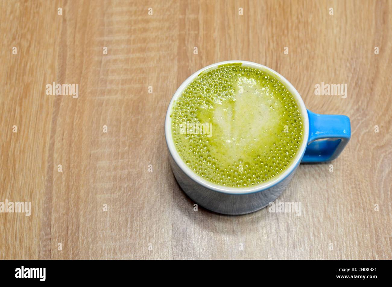tazza blu con tè matcha verde frothy Foto Stock