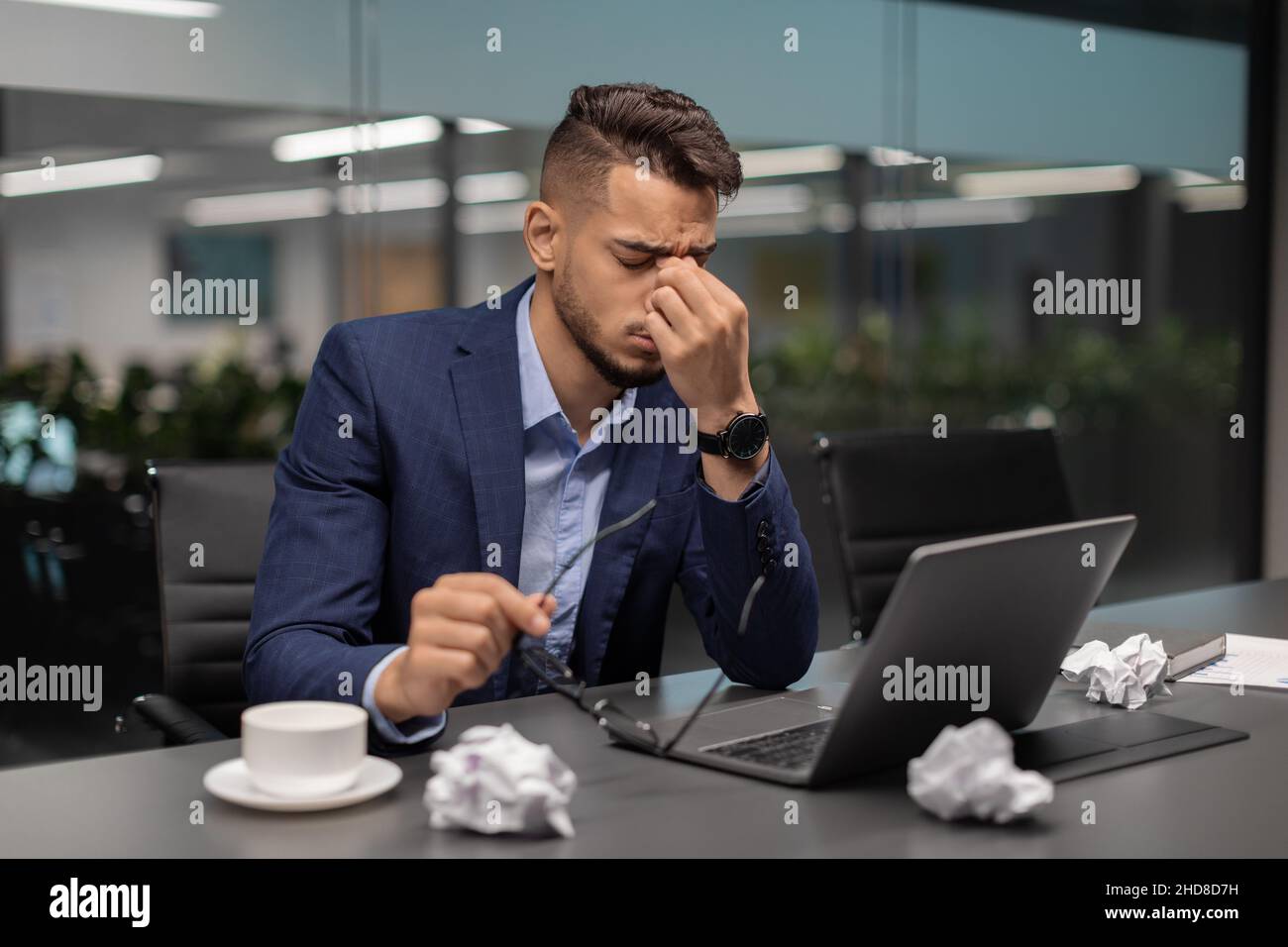 Ragazzo arabo stanco CEO che lavora sul laptop in ufficio Foto Stock