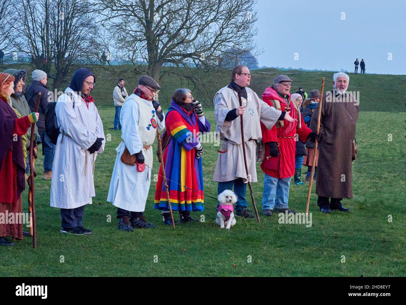 Raduno di Druids e amici in Avebury henge al solstizio d'inverno 2021 che fa un'offerta ' Hail and Farewell ' al sole del tramonto - Wiltshire UK Foto Stock