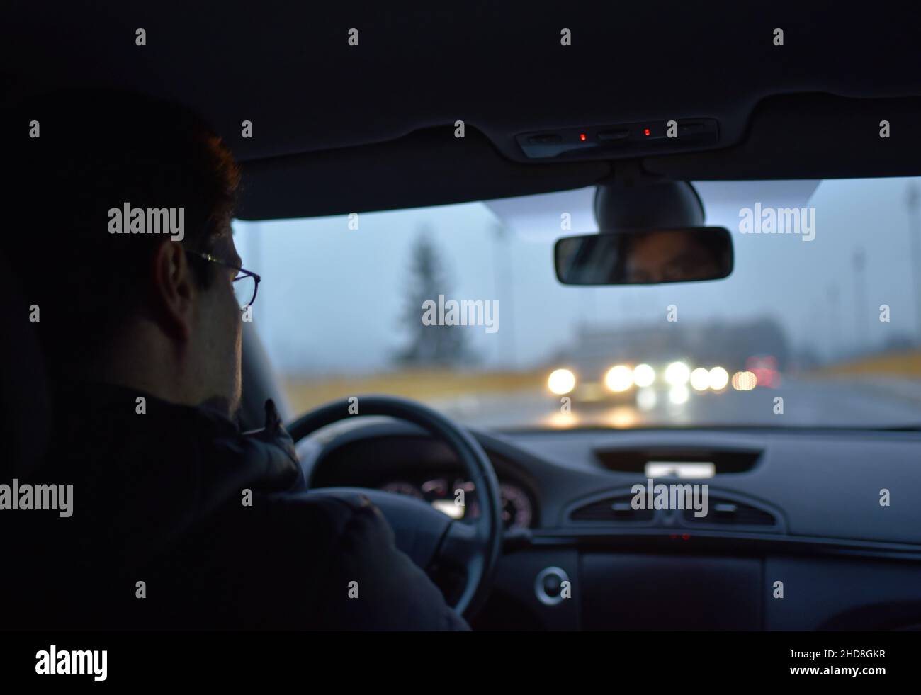 l'uomo guida un'auto la sera, in un inverno asciutto Foto Stock