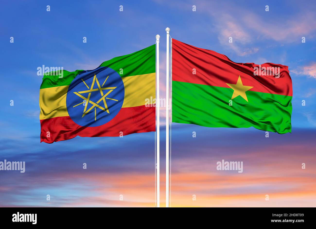 Etiopia Burkina Faso due bandiere su flagpoli e cielo nuvoloso blu Foto Stock