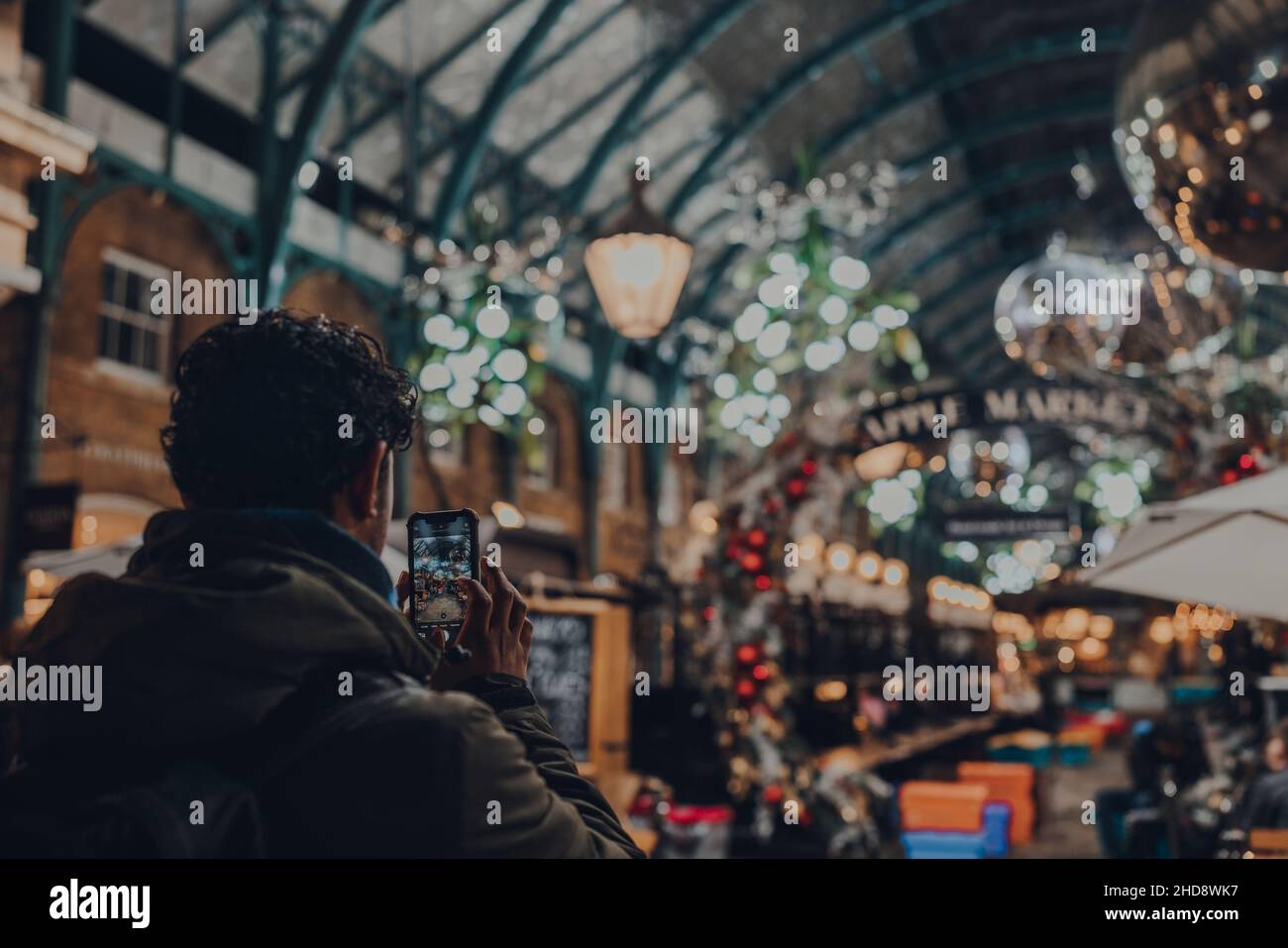 Londra, UK - 23 novembre 2021: Uomo che scatta foto delle decorazioni natalizie a Covent Garden Market, uno dei siti turistici più popolari di Londra, o Foto Stock