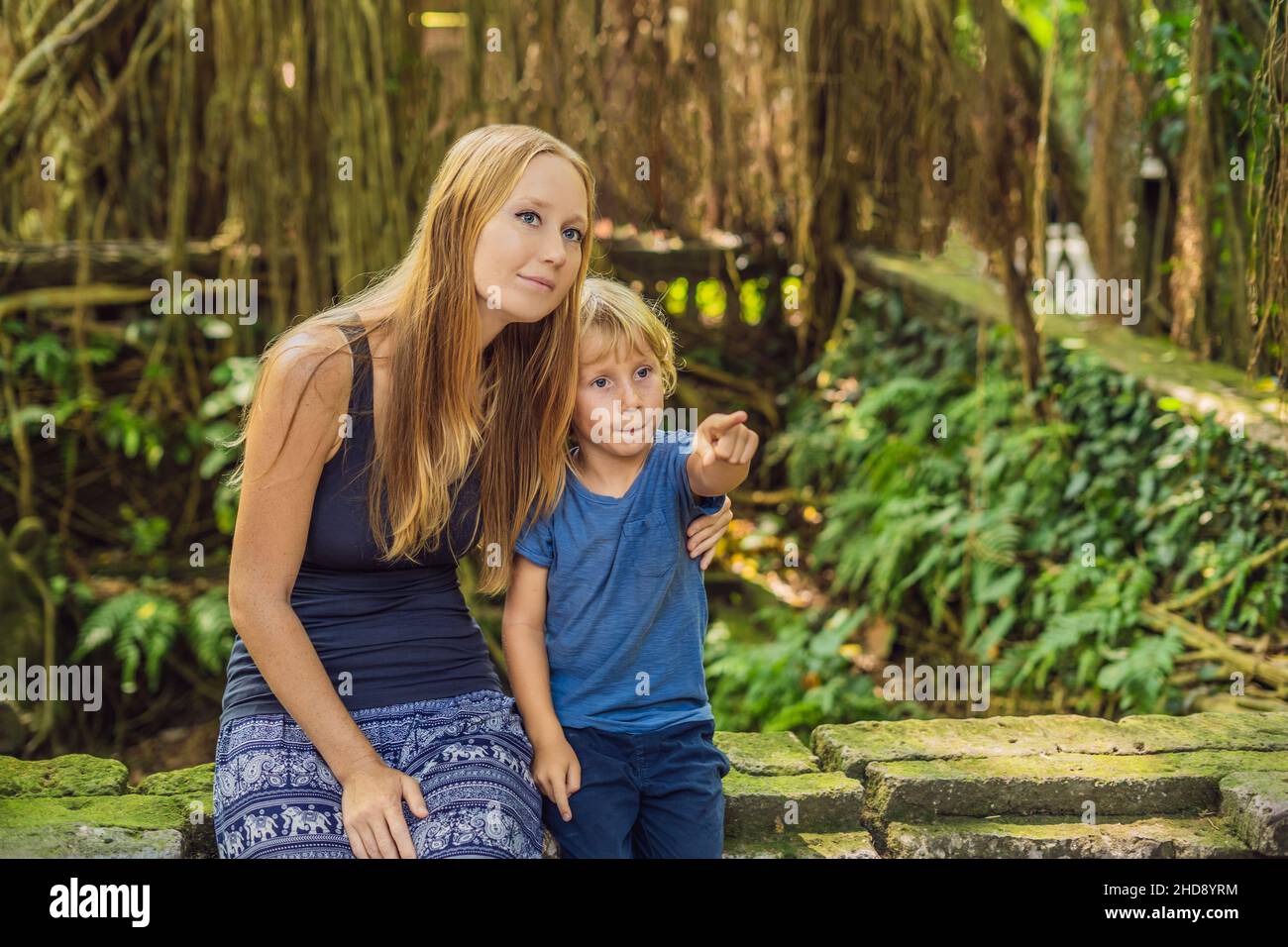 Madre e figlio i viaggiatori alla scoperta della foresta Ubud nella foresta delle scimmie, Bali Indonesia. Viaggiare con bambini di concetto Foto Stock