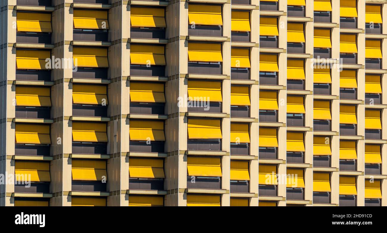 Facciata di un edificio dalle tonalità del sole gialle uniformi, tutte chiuse, Foto Stock