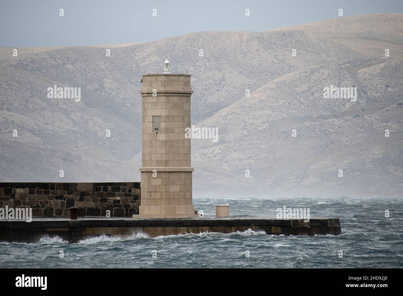 faro su un molo con acque tempestose Foto Stock faro su un molo con acque tempestose Foto Stock