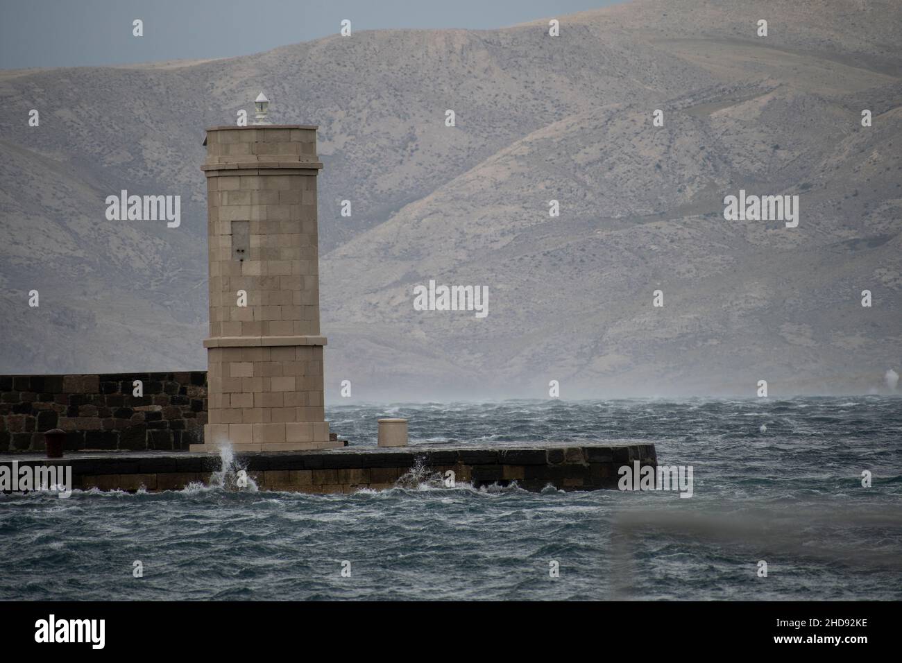 faro su un molo con acque tempestose Foto Stock faro su un molo con acque tempestose Foto Stock