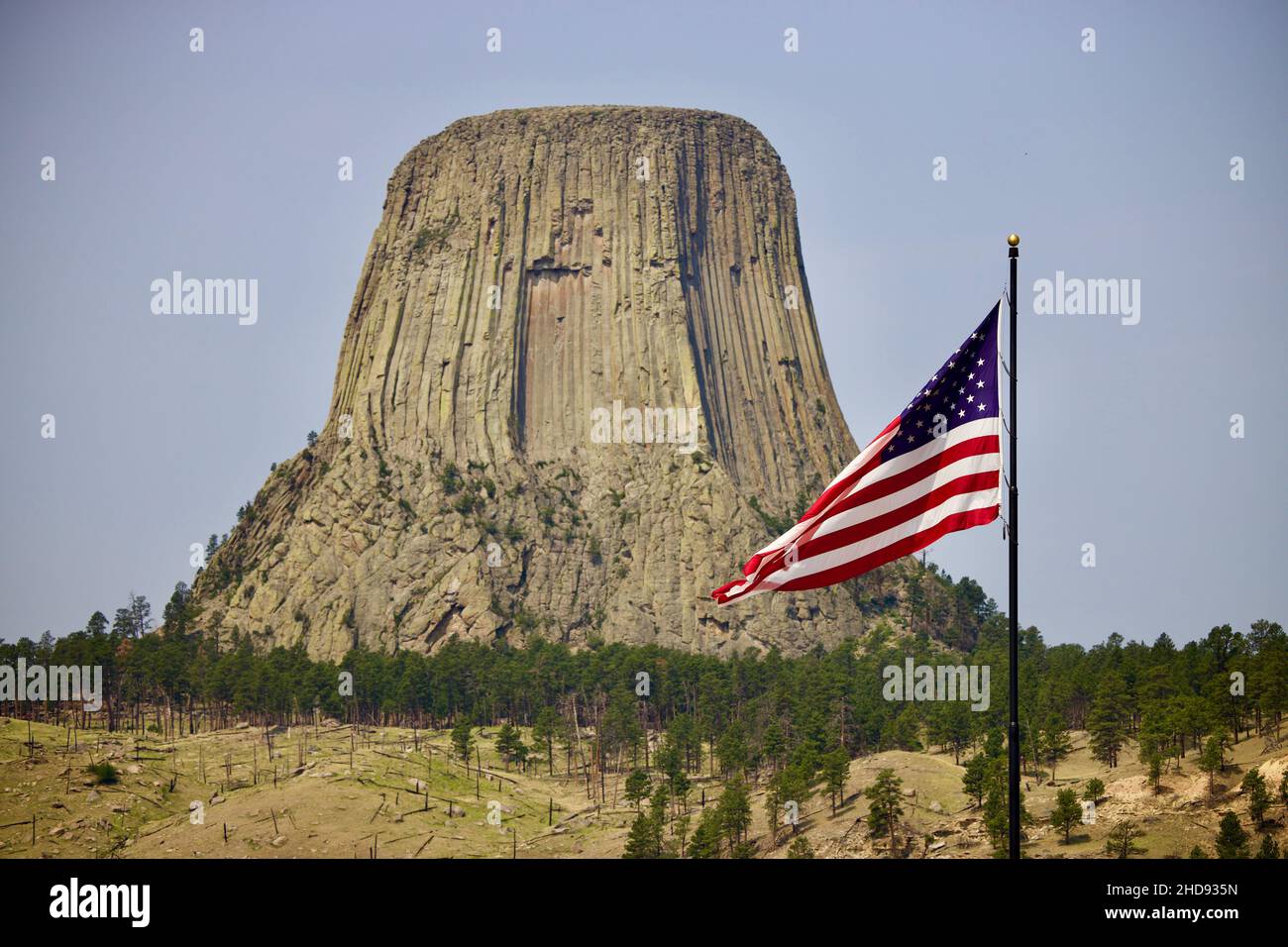 Vista panoramica del Devils Tower National Monument e della bandiera degli Stati Uniti Foto Stock